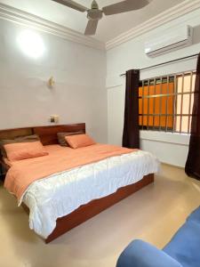 a bedroom with a large bed with orange and white sheets at deux chambres et salon chez 198 à Porto Novo in Porto-Novo