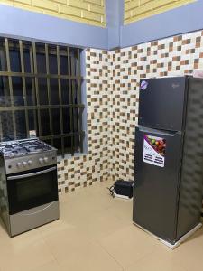 a kitchen with a stove and a refrigerator at deux chambres et salon chez 198 à Porto Novo in Porto-Novo