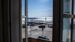 uma vista para a praia a partir de uma janela em Porto Beach House em Porto