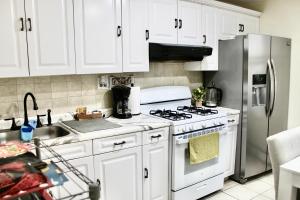 a kitchen with white cabinets and a stainless steel refrigerator at Private Room A-KING BED-12Mints NYCity Times Square in West New York