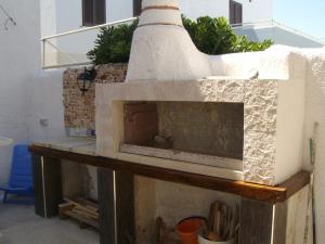 una chimenea de piedra en la sala de estar con en Villino Carolina 30 mt mare, en Porto Cesareo