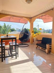 a living room with a table and a chair at trois chambres et salon avec balcon à Porto Novo in Porto-Novo