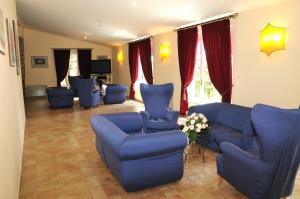 a living room with blue chairs and couches at Villa Irlanda Grand Hotel in Gaeta