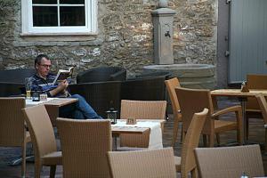 a man sitting at a table reading a book at Goldener Adler in Sulzheim