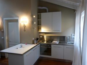 a kitchen with white cabinets and a counter top at Residenza Porta D'Azeglio in Bologna