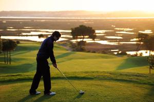 a man is playing golf on a golf course at Precise Resort El Rompido-The Hotel in El Rompido