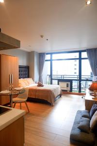 Un dormitorio con una cama y una ventana grande. en Condo in Makati with Fast WiFi, Free Pool, Netflix and Own Balcony, en Manila