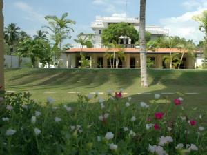 a view of a house with flowers in the foreground at Sagarika Beach Hotel in Moragalla
