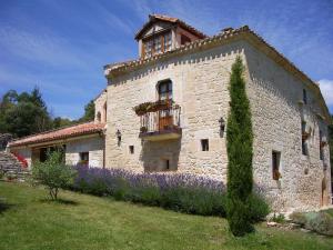 a large stone building with a balcony and purple flowers at La Ondina in Salazar