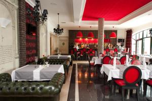 restauracja z białymi stołami i czerwonymi krzesłami w obiekcie Hotel Royal Baltic 4* Luxury Boutique w Ustce