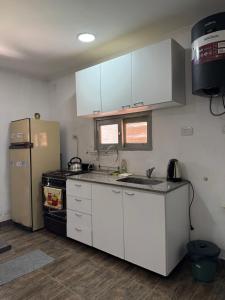 フェデラシオンにあるTu lugar de Descansoの白いキャビネットと冷蔵庫のあるキッチン