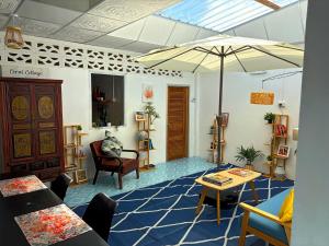 - un salon avec une table et un parasol dans l'établissement Coral Cottage Beach House @ Phang Nga, à Thai Muang