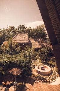 een uitzicht op een tuin met een parasol en planten bij Lulu's Villas in Uluwatu