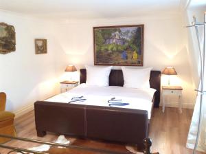 een slaapkamer met een bed met een schilderij aan de muur bij Royal Guest House in Dülken