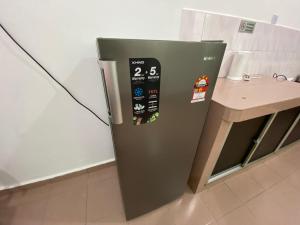 a refrigerator in a kitchen next to a table at Pagoh Town homestay 2 in Pagoh