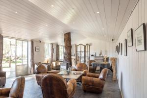 a living room with leather chairs and a table at Hôtel Restaurant & Spa Plaisir in Le Bois-Plage-en-Ré