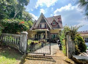 a house with a gate in front of it at Villa Sevilla 3 Bedrooms BPPK Ciloto Puncak by Damaresa in Tjiandjur