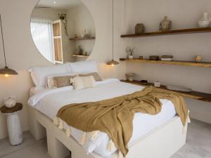 a bedroom with a large white bed with a blanket on it at Bali Escapes- Studio And 1 Bedroom Villa in Uluwatu
