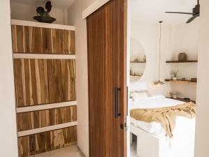a bedroom with a bed and a wooden door at Bali Escapes- Studio And 1 Bedroom Villa in Uluwatu