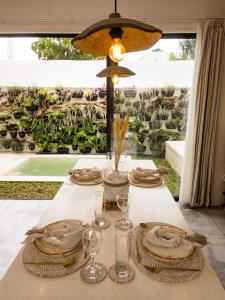 a table with plates and glasses on top of it at Bali Escapes- Studio And 1 Bedroom Villa in Uluwatu