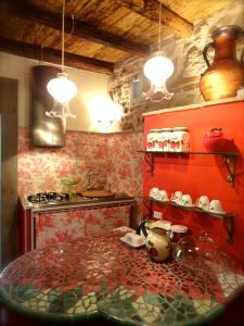 a kitchen with red walls and a table with pots and pans at Vistalago Guesthouse in Nemi