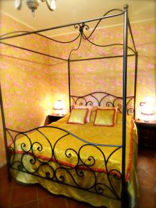 a bedroom with a bed with a metal canopy at Vistalago Guesthouse in Nemi
