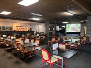 a dining room with tables and chairs and a screen at The Club Hotel Collie in Collie