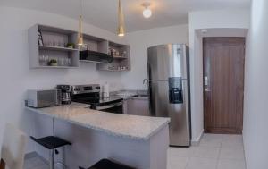 a kitchen with a stainless steel refrigerator at Condo 9, San Francisco Tower in San Salvador