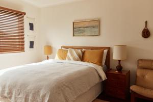 ヤンバにあるBAY PROPERTIES . The Sailors Upper Deckのベッドと椅子のある寝室 +6枚の写真
