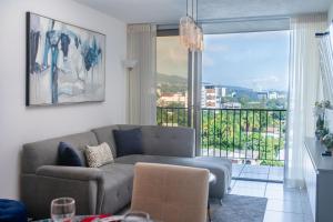 a living room with a couch and a large window at Condo 9, San Francisco Tower in San Salvador