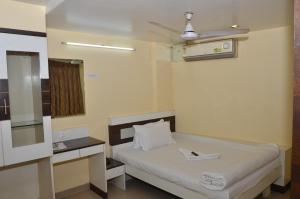 a hospital room with a bed and a mirror at Da Casa Business Hotel in Pune