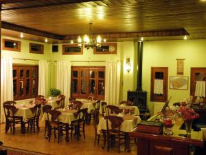 a dining room with tables and chairs and a chandelier at Hotel Mpakou in Elati