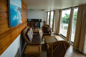 Una sala de estar con sillas de mimbre y un sofá. en Landrigan Apartments, en San Juan