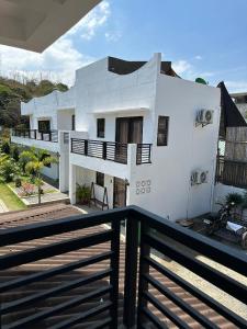 una casa blanca con una valla negra delante de ella en Landrigan Apartments, en San Juan