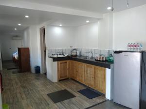 Una cocina con refrigerador blanco y gabinetes de madera. en Landrigan Apartments, en San Juan