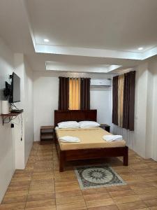Un dormitorio con una cama y un televisor. en Landrigan Apartments, en San Juan