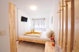 una camera da letto con un letto con lenzuola bianche e una finestra di Albergo Pontafel a Pontebba