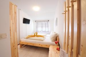 a bedroom with a bed with white sheets and a window at Albergo Pontafel in Pontebba