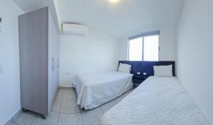 a bedroom with two beds and a window at Condo 9, San Francisco Tower in San Salvador +27 photos
