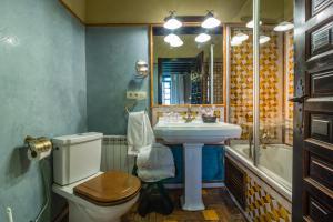 a bathroom with a toilet and a sink and a tub at Palacio de Mariana Pineda in Granada +55 photos