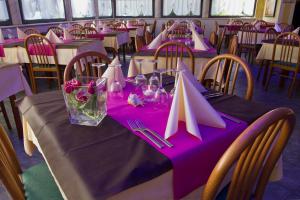 a table with purple table cloth and pink napkins at Hotel La Fenice in Lignano Sabbiadoro