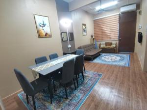 a room with a table and chairs and a living room at JSA Homestay Seremban in Seremban