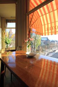 une table en bois avec un vase au-dessus dans l'établissement Hotel Museumzicht, à Amsterdam