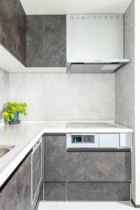 a kitchen with white cabinets and a stove top oven at 鎌倉由比ガ浜Home in Kamakura