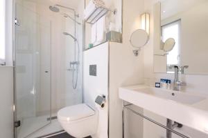 a bathroom with a toilet and a sink and a shower at Hôtel Gustave in Paris +54 photos