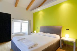 1 dormitorio con cama blanca y pared verde en B&B al Palazzo Malfatti, en Trento