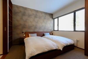 een slaapkamer met een bed en een groot raam bij Setsurin 雪林 in Niseko