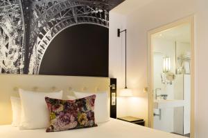a bedroom with a white bed and white walls at Hôtel Gustave in Paris