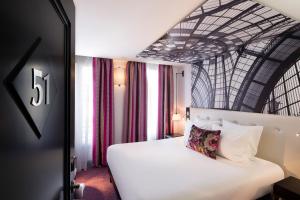 パリにあるオテル グスタボの白いベッドが備わる客室と、看板が備わる客室を提供しています。