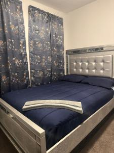 una camera da letto con un letto con un piumone blu di Jorge Salcido a Long Beach